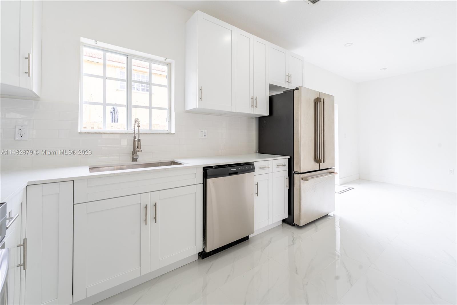 14346 Southwest 134th Place Miami, FL 33186 - Photo 6 of 36 a kitchen with white cabinets and white appliances
