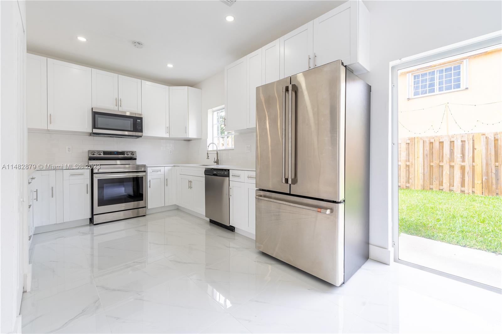 14346 Southwest 134th Place Miami, FL 33186 - Photo 7 of 36 a kitchen with stainless steel appliances granite countertop a refrigerator a stove a sink and a microwave