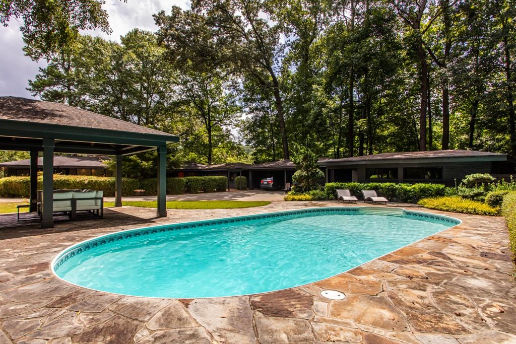 1904 Lenox Road Northeast Atlanta, GA 30306 - Photo 38 of 56 a view of a swimming pool with lawn chairs under an umbrella