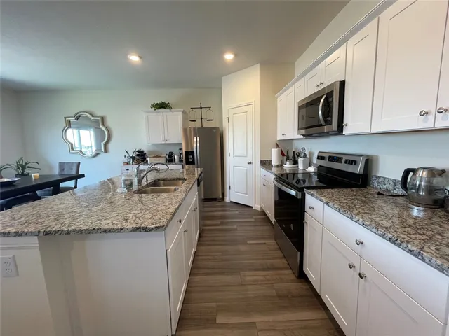 a kitchen with stainless steel appliances granite countertop a sink stove and microwave
