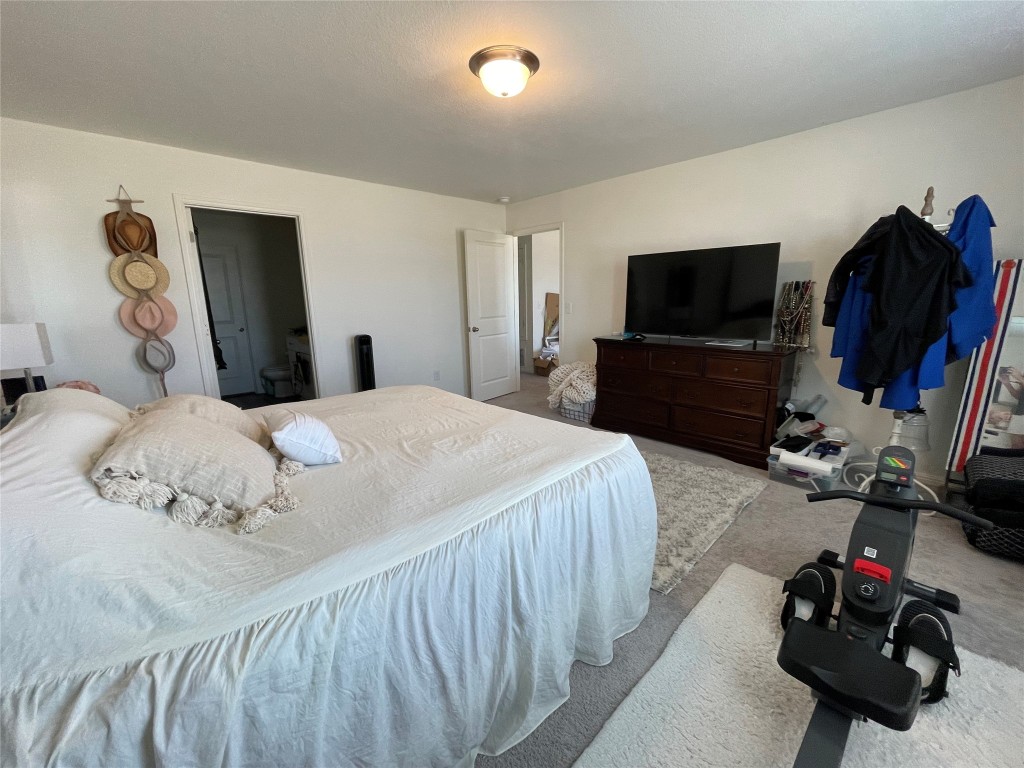 201 Comancheros Road Jarrell, TX 76537 - Photo 22 of 33 The primary bedroom is located off the loft & has plenty of space for the King sized bed.