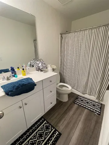 a spacious bathroom with a sink a toilet and a mirror