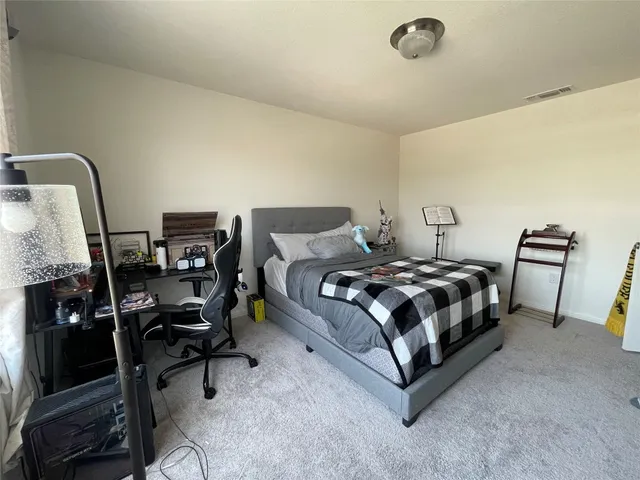 a bedroom with a bed a desk and chair