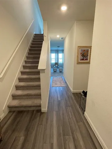 a view of a hallway with wooden floor and stairs