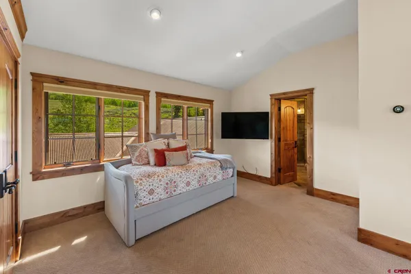 a bedroom with a bed and large windows