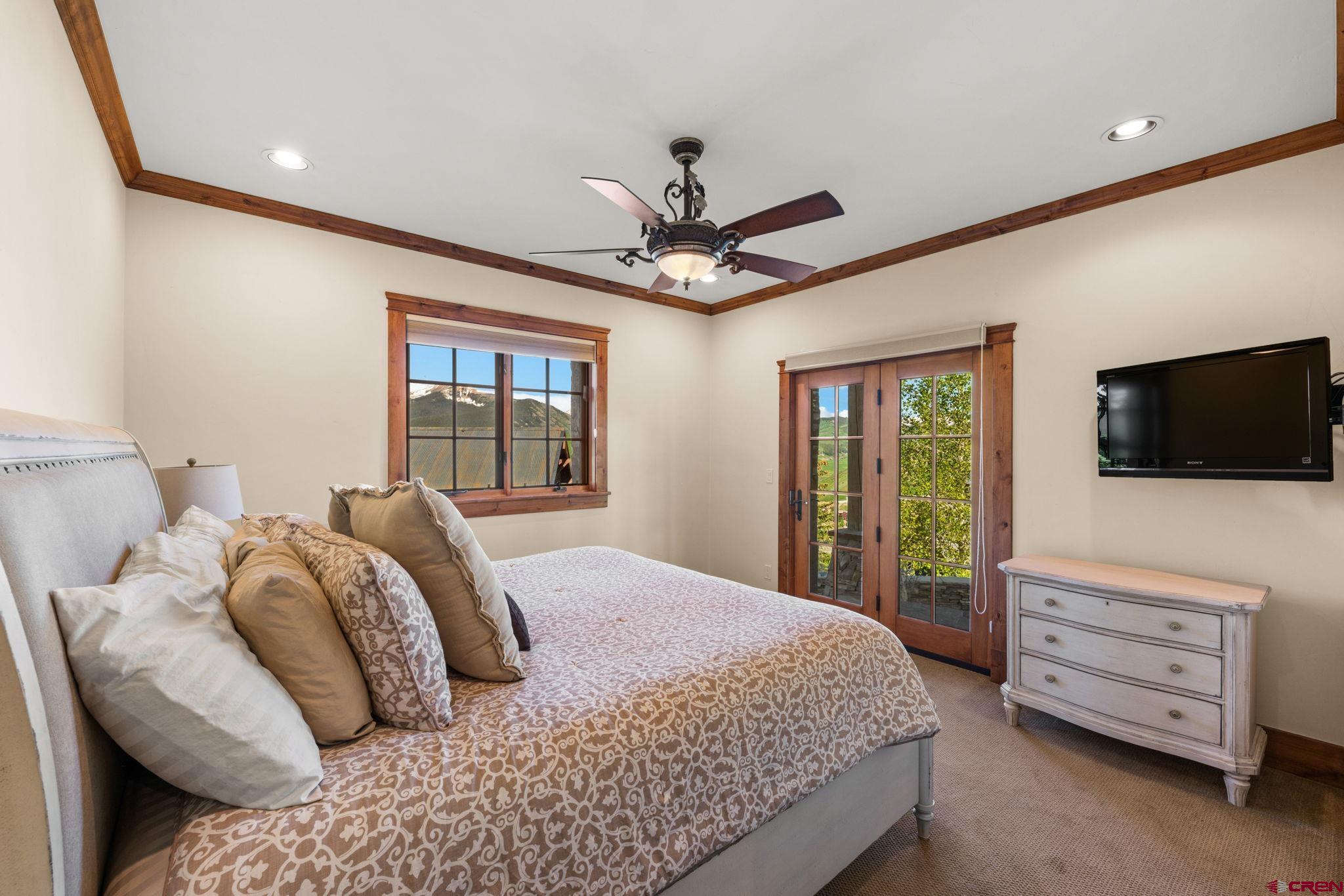 59 Summit Road Crested Butte, CO 81225 - Photo 31 of 45 a bedroom with a bed a dresser and a flat screen tv