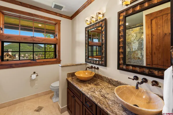 a bathroom with a granite countertop sink and a large mirror