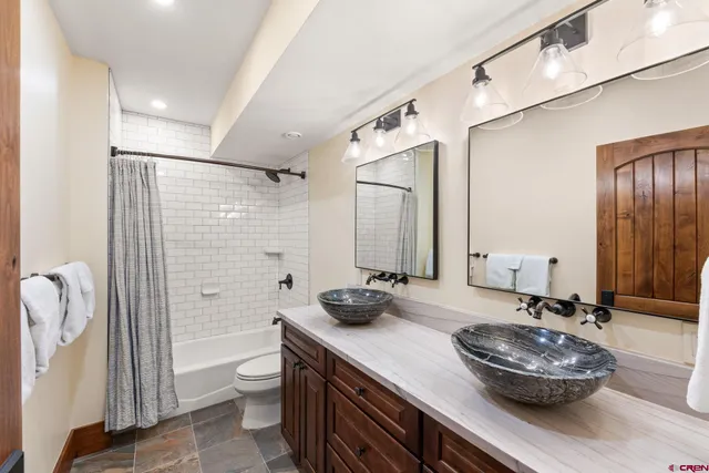 a bathroom with a granite countertop sink a toilet and shower