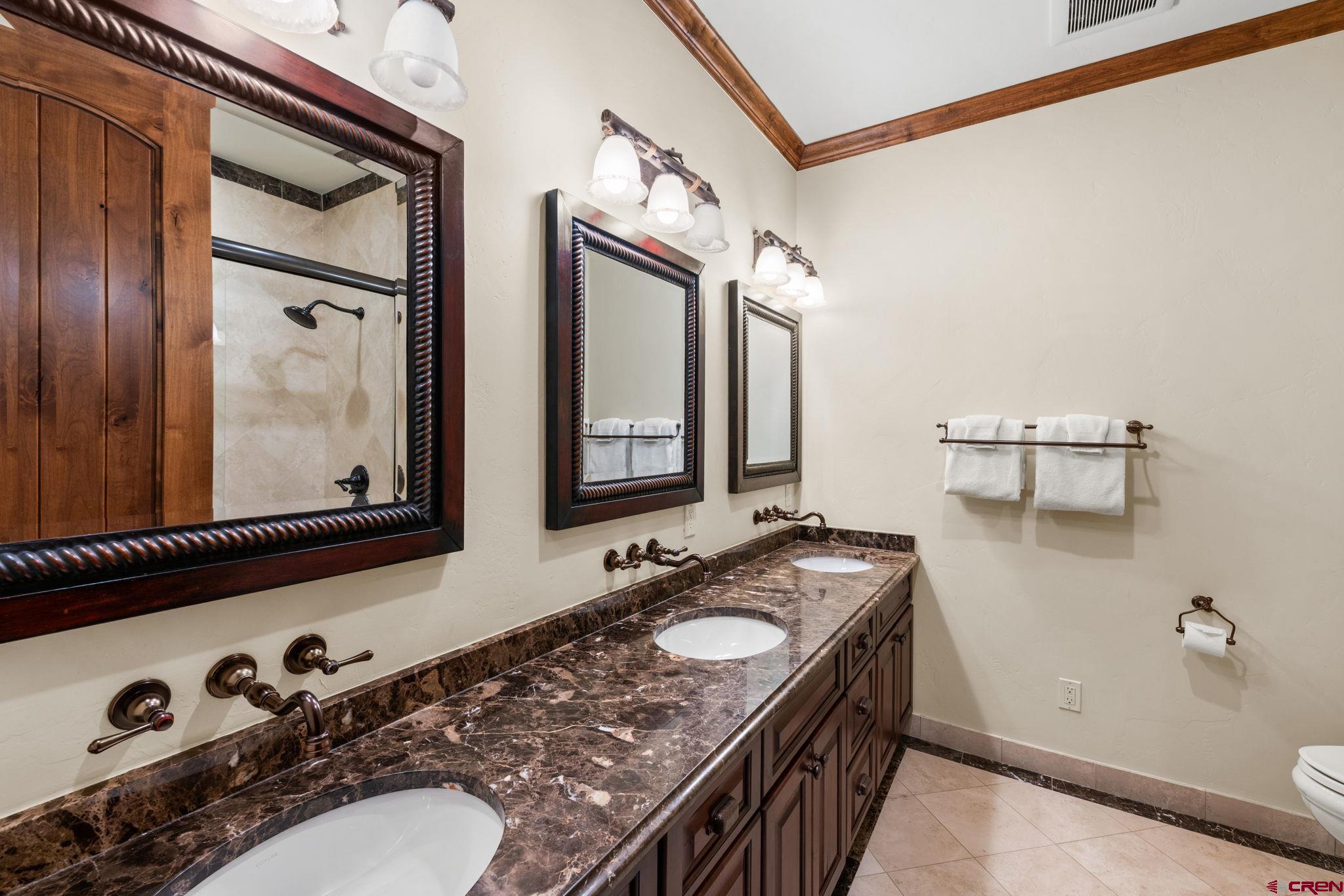 59 Summit Road Crested Butte, CO 81225 - Photo 39 of 45 a bathroom with a granite countertop sink a mirror and shower