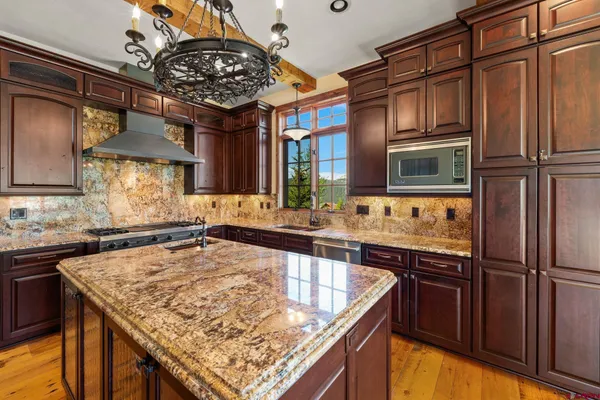 a kitchen with stainless steel appliances granite countertop a sink and a refrigerator