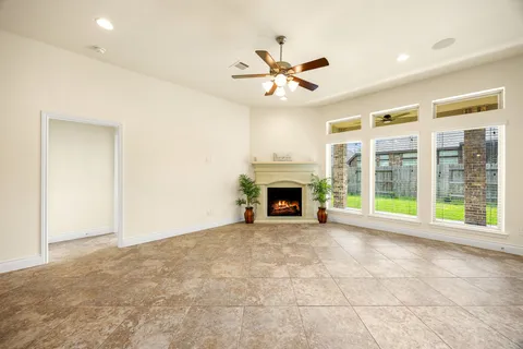 a view of an empty room with a fireplace and a window