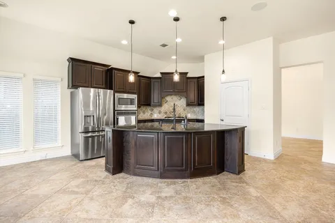 a kitchen with stainless steel appliances granite countertop a refrigerator a stove a sink and a refrigerator