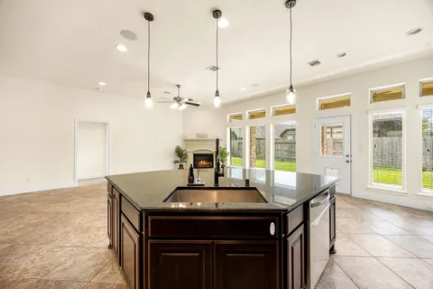 a kitchen with stainless steel appliances granite countertop a sink a stove and a wooden floor