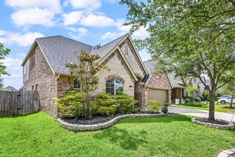 a front view of a house with a yard and fountain
