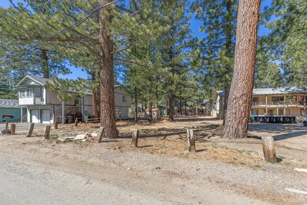 a view of a house with backyard and trees