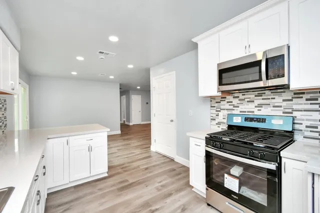a kitchen with stainless steel appliances a stove microwave and cabinets
