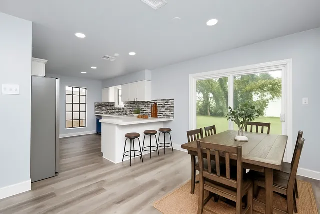 a dining room with furniture and a floor to ceiling window