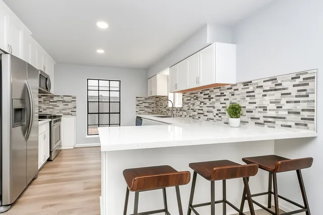 a kitchen with stainless steel appliances kitchen island granite countertop a table and chairs in it