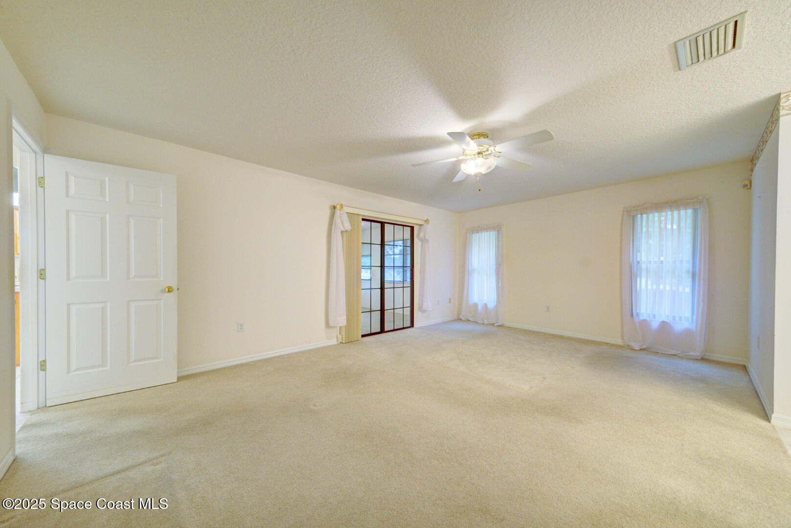3105 Diamond Road Titusville, FL 32796 - Photo 22 of 81 a view of an empty room with window and chandelier fan