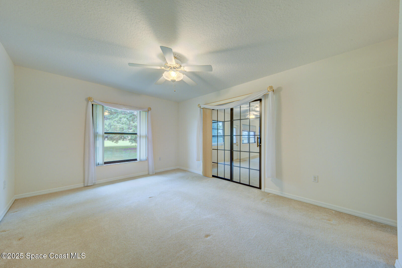 3105 Diamond Road Titusville, FL 32796 - Photo 38 of 81 an empty room with windows and ceiling fan