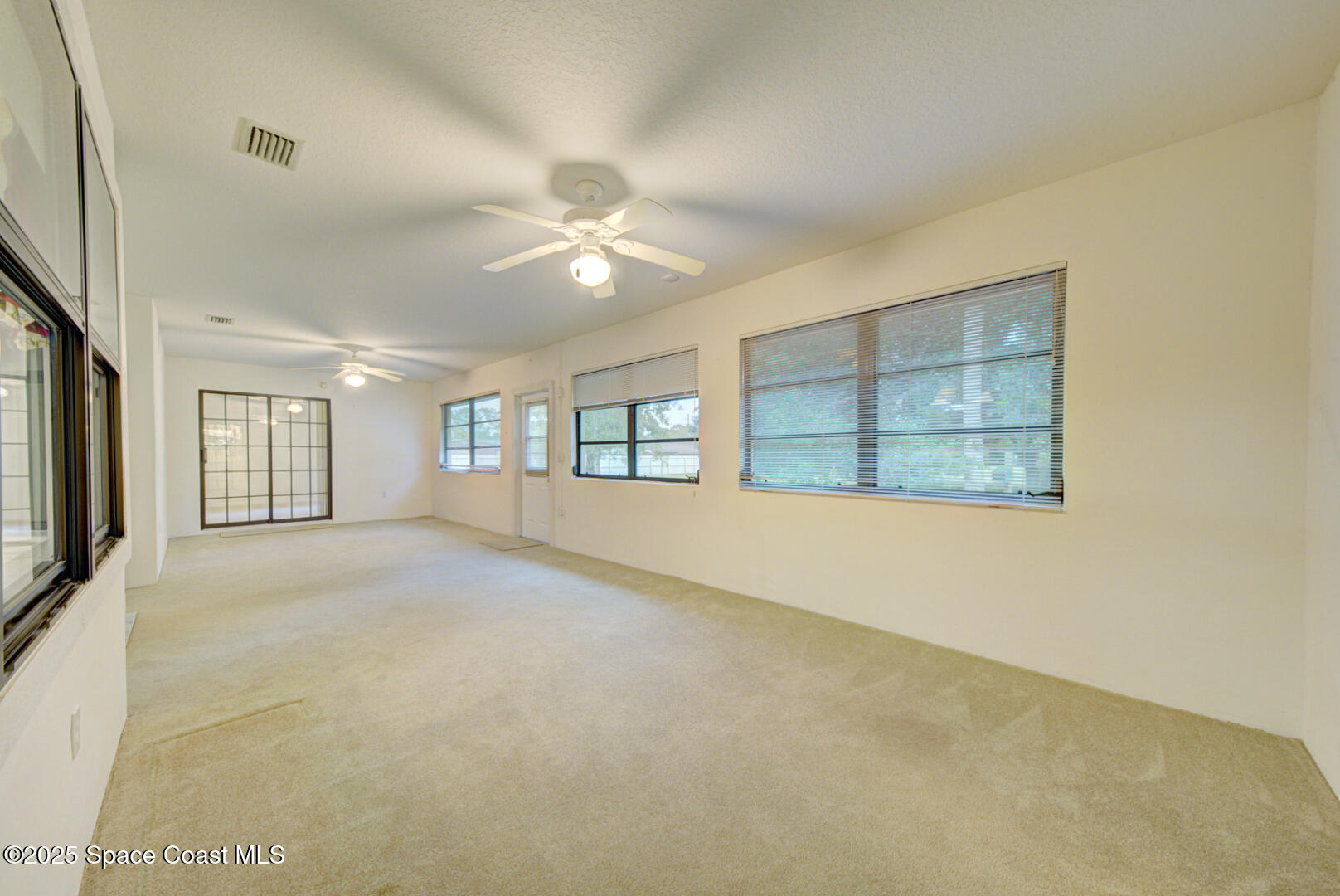 3105 Diamond Road Titusville, FL 32796 - Photo 50 of 81 an empty room with chandelier fan and windows