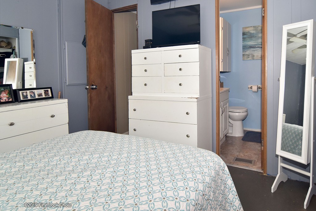 301 Bulgarmarsh Road, Unit F7 Tiverton, RI 02878 - Photo 21 of 30 a bedroom with a bed and a flat tv screen in it