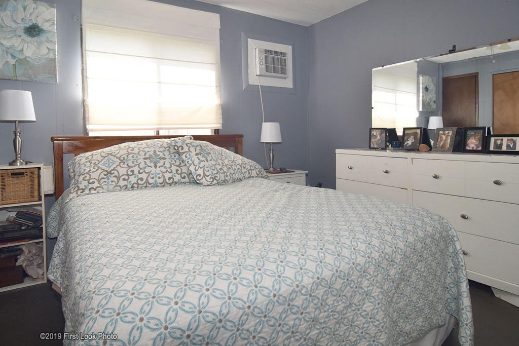 301 Bulgarmarsh Road, Unit F7 Tiverton, RI 02878 - Photo 26 of 30 a bedroom with a large bed and a dresser