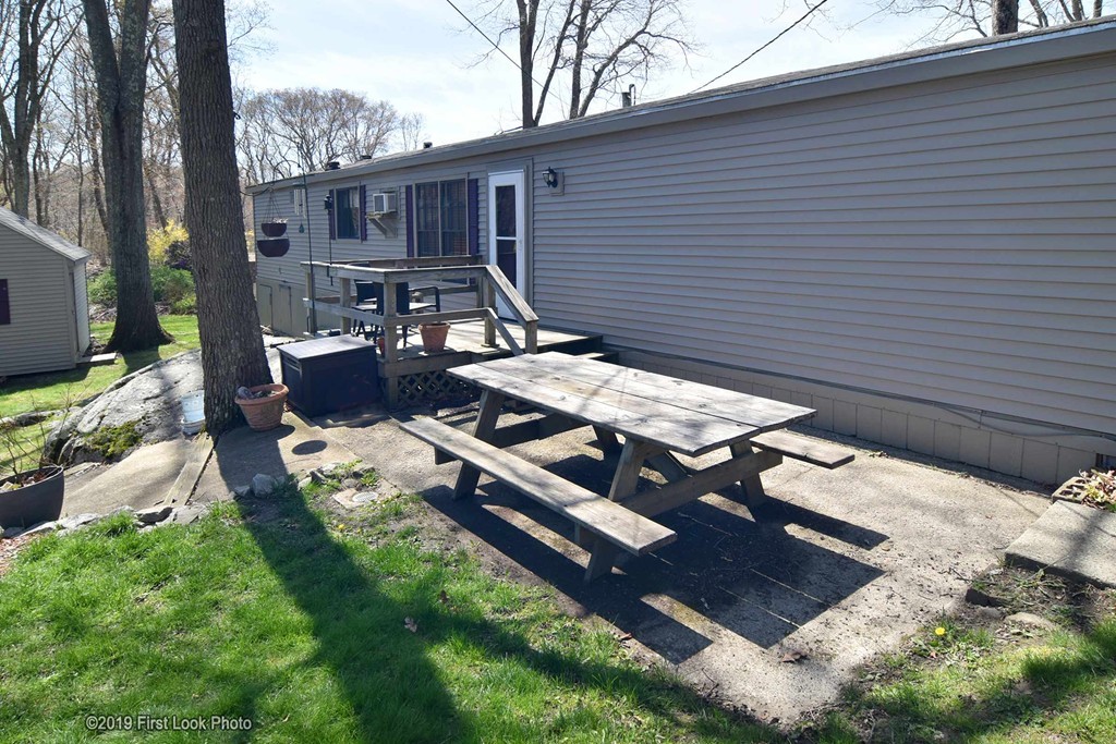 301 Bulgarmarsh Road, Unit F7 Tiverton, RI 02878 - Photo 27 of 30 a backyard of a house with table and chairs