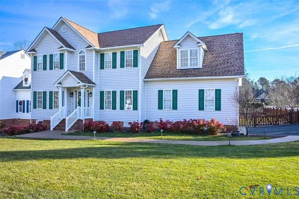 a front view of a house with a garden and yard