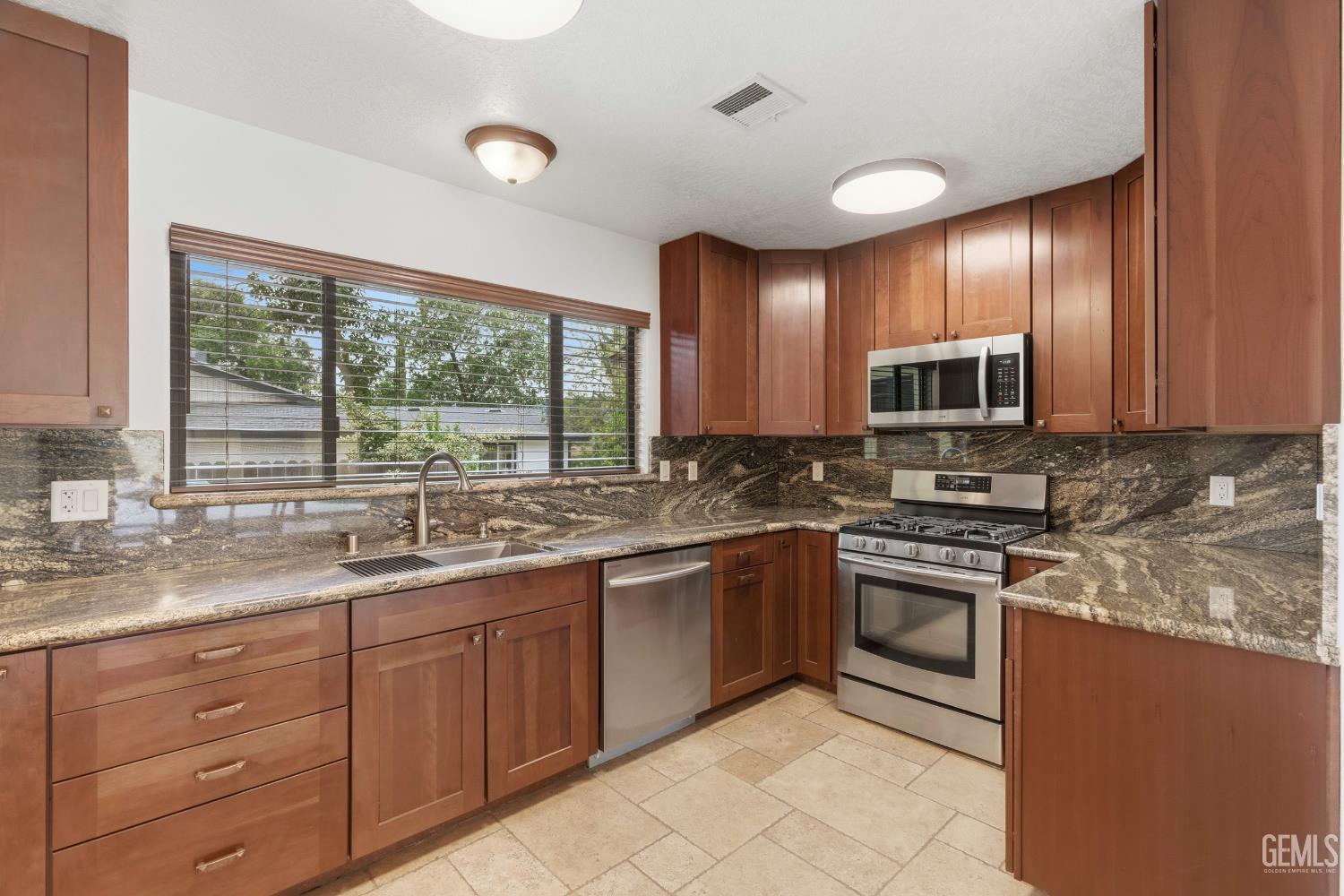 Undisclosed Address Springville, CA 93265 - Photo 18 of 62 a kitchen with stainless steel appliances granite countertop wooden cabinets and a stove top oven