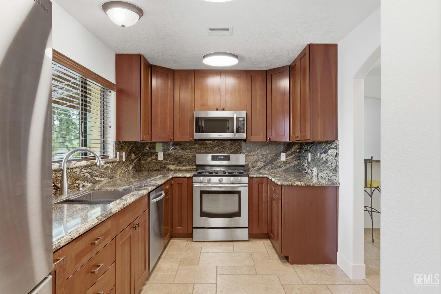 Undisclosed Address Springville, CA 93265 - Photo 23 of 62 a kitchen with stainless steel appliances granite countertop a stove a sink and a microwave