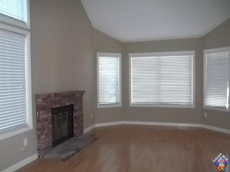 1726 East Ave R12 Palmdale, CA 93550 - Photo 4 of 12 an empty room with a fireplace and windows