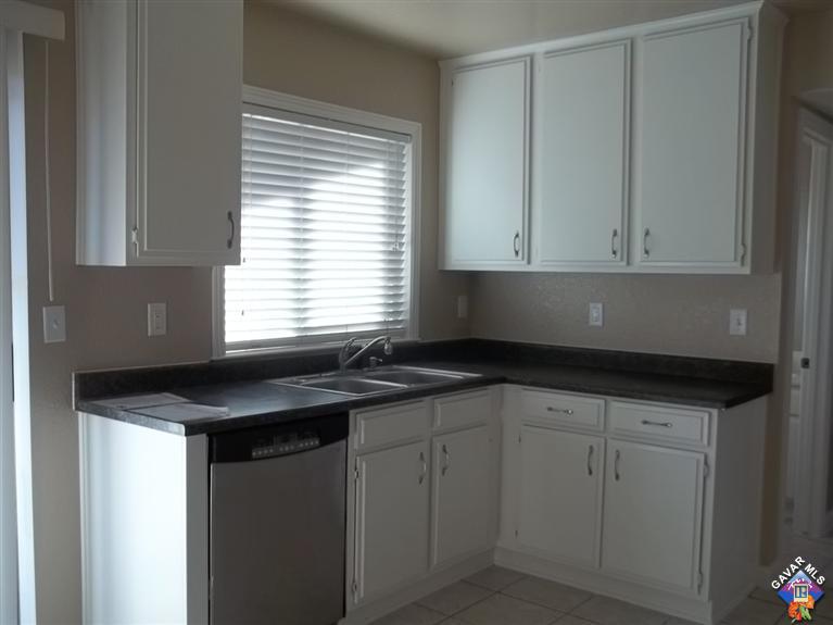 1726 East Ave R12 Palmdale, CA 93550 - Photo 6 of 12 a kitchen with granite countertop white cabinets and a sink
