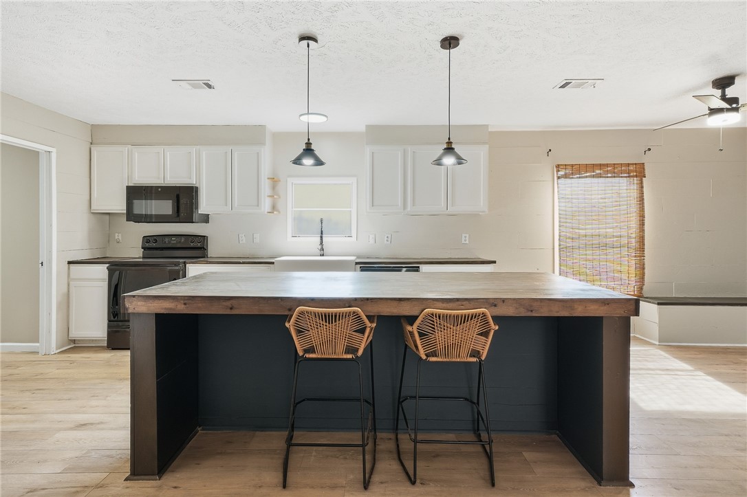 124 County Road 632 Sinton, TX 78387 - Photo 12 of 40 a open kitchen with stainless steel appliances granite countertop a stove a refrigerator and a kitchen island