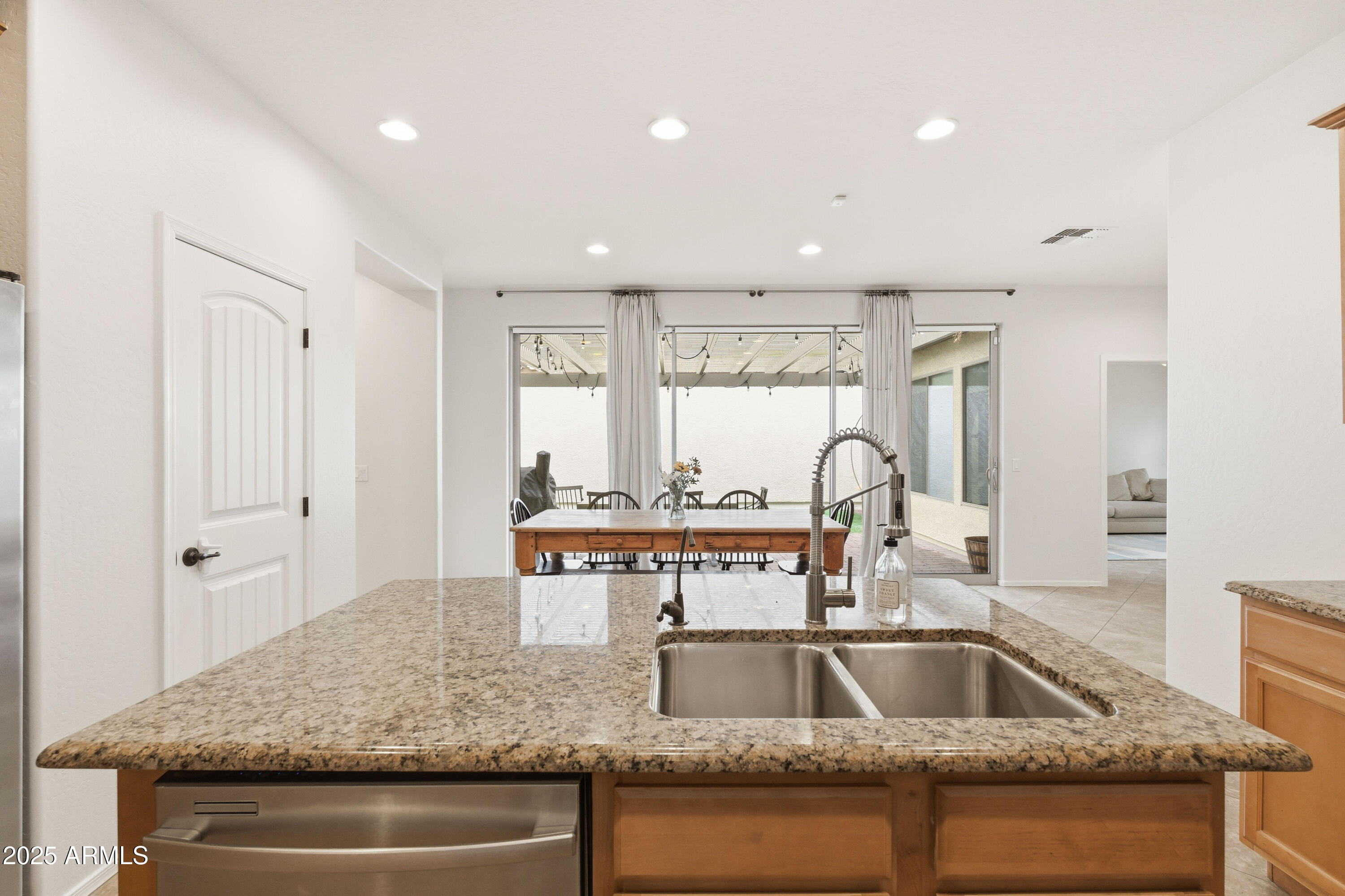 4495 East Woodside Way Gilbert, AZ 85297 - Photo 24 of 80 a kitchen with kitchen island granite countertop a sink and wooden cabinets