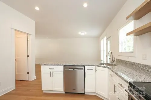 a view of a kitchen with granite countertop a sink and a stove top oven