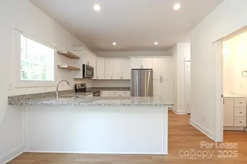 a kitchen with stainless steel appliances granite countertop a sink a stove and a refrigerator