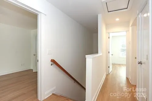 a view of a hallway with wooden floor and staircase
