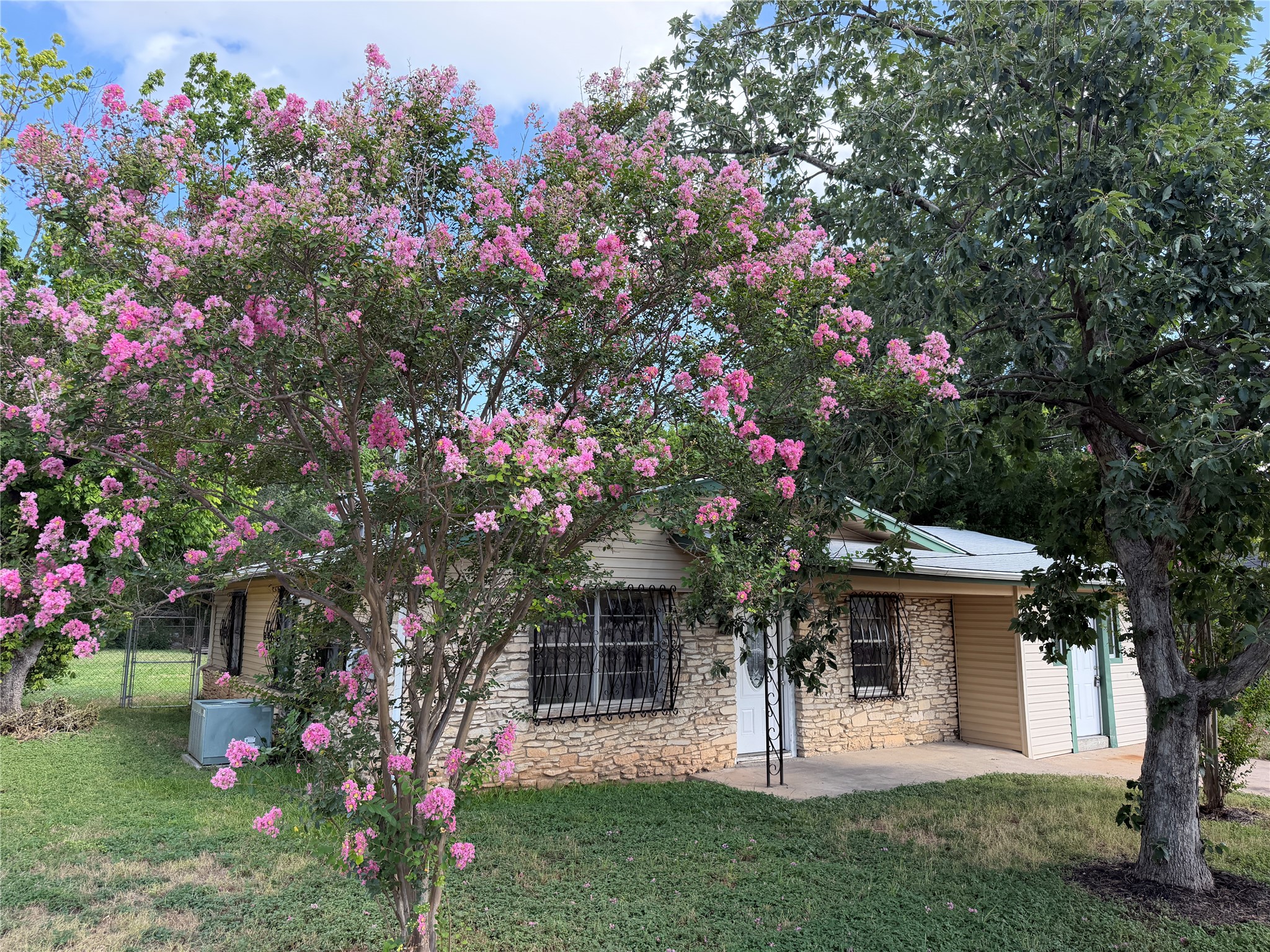 1060 Gardner Road Austin, TX 78721 - Photo 4 of 19 Stone veneer siding accents this charming home with a delightful blooming tree out front.