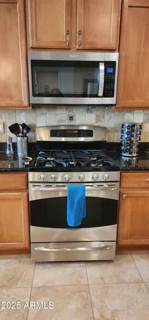a kitchen with granite countertop a stove and a microwave