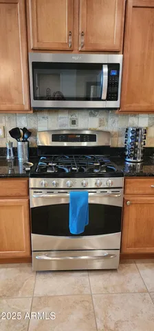 a kitchen with granite countertop a stove and a microwave