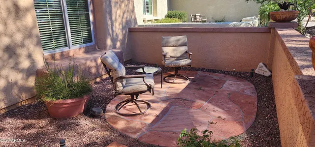 a view of a backyard with plants and table