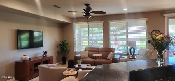a living room with furniture a chandelier and a flat screen tv