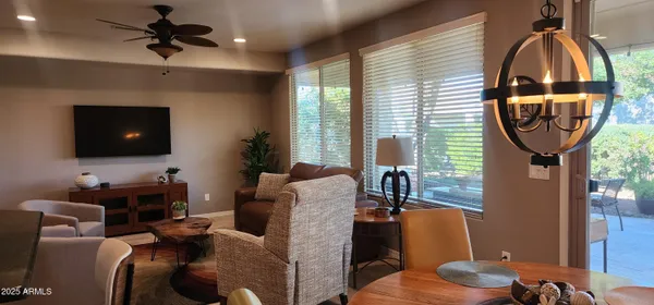 a living room with furniture a flat screen tv and a large window