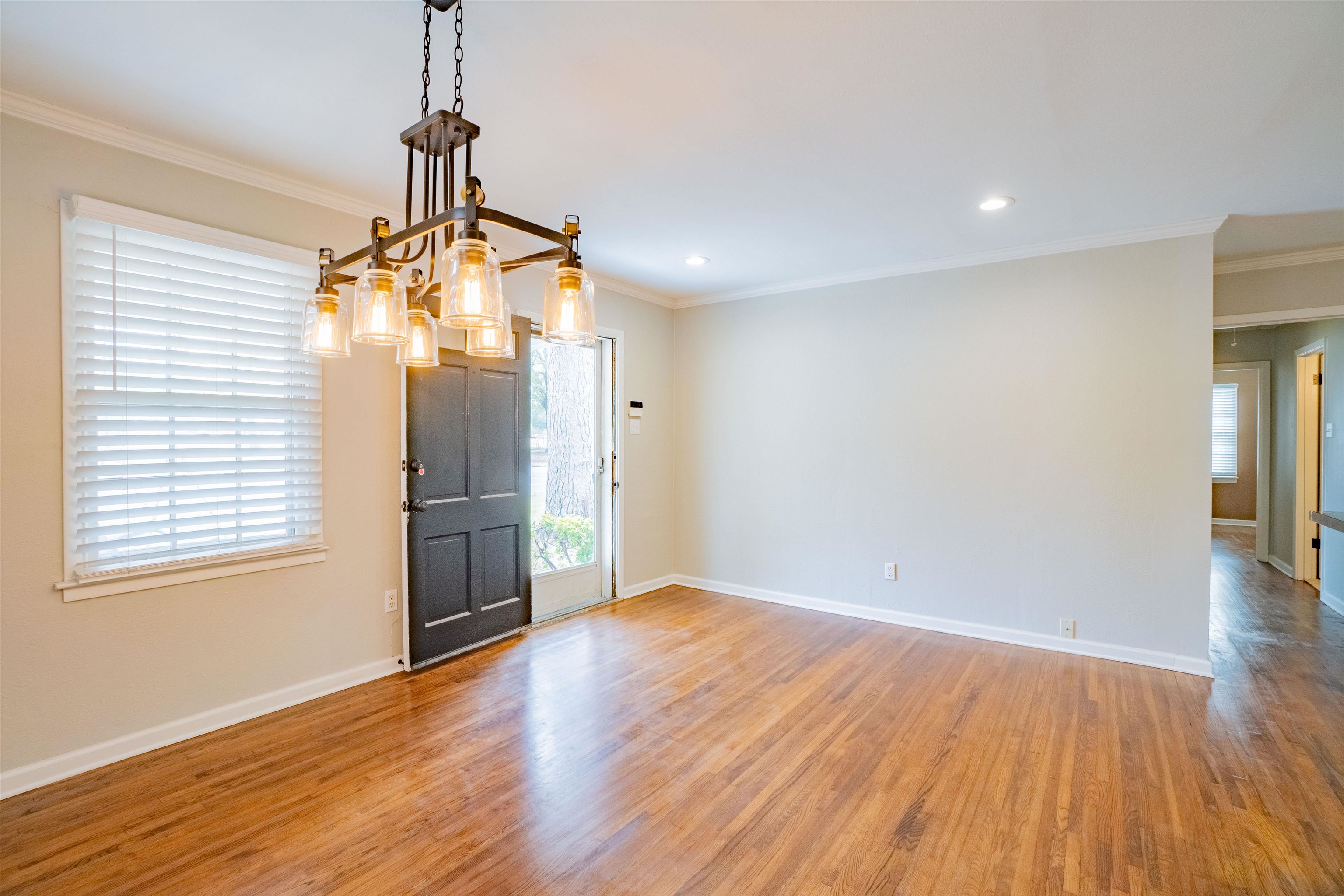 1349 Colonial Road Memphis, TN 38117 - Photo 6 of 29 a view of a room with wooden floor a ceiling fan and windows