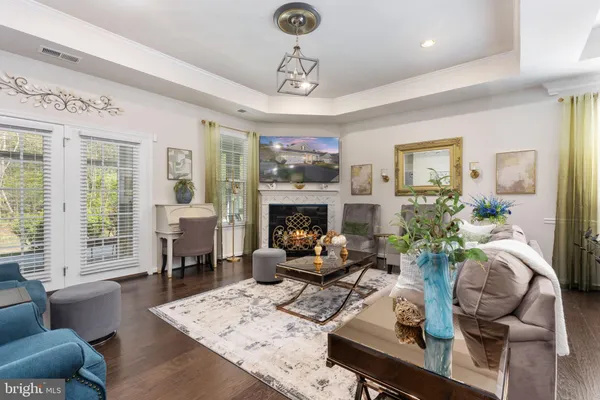 a living room with furniture a fireplace and a chandelier