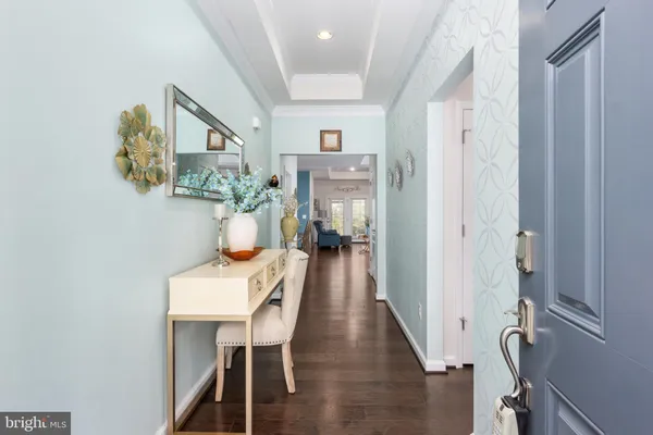 a view of a hallway with furniture and wooden floor
