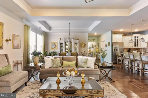 a living room with furniture and a dining table with wooden floor