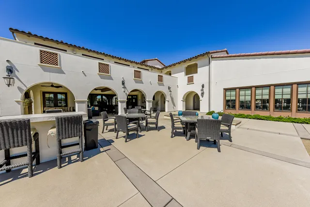 a view of a patio with dining table and chairs with wooden fence