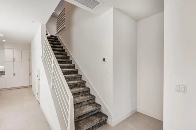 a view of a hallway with stairs and wooden floor